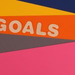 Vibrant abstract image with the word 'Goals' on multi-colored paper background.